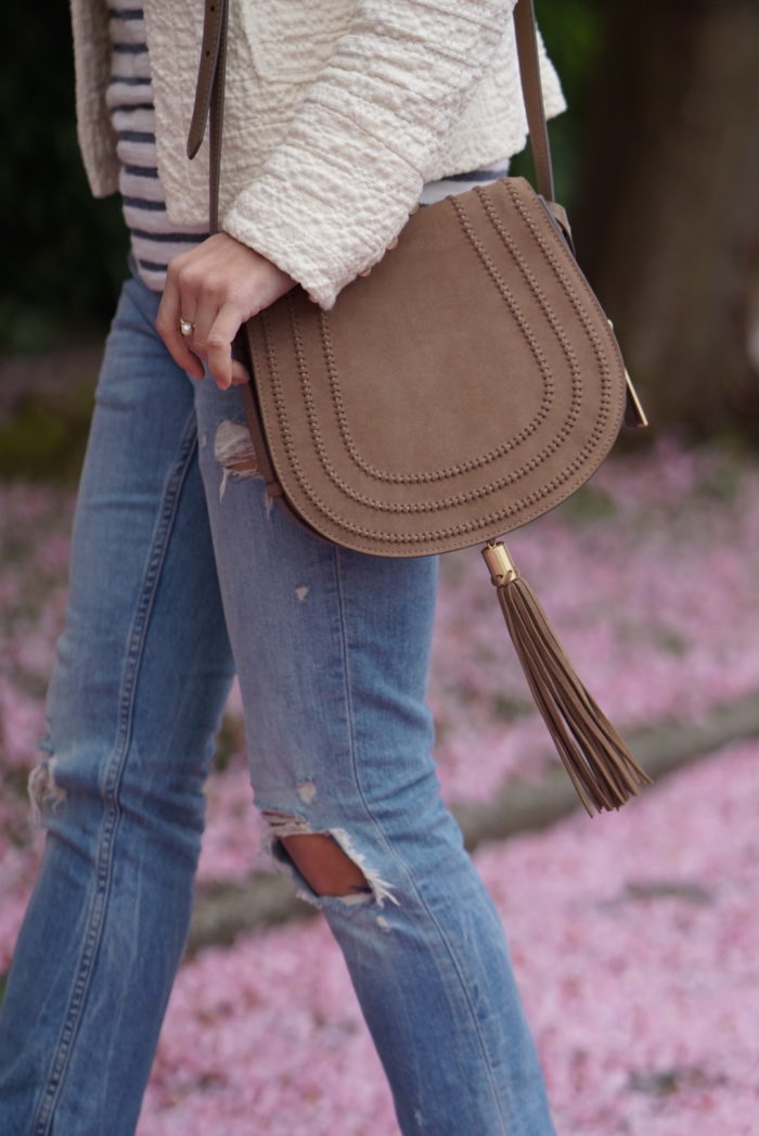 Christine Cameron wearing a vince camuto saddle bag next to cherry blossoms on queen anne hill in seattle 2