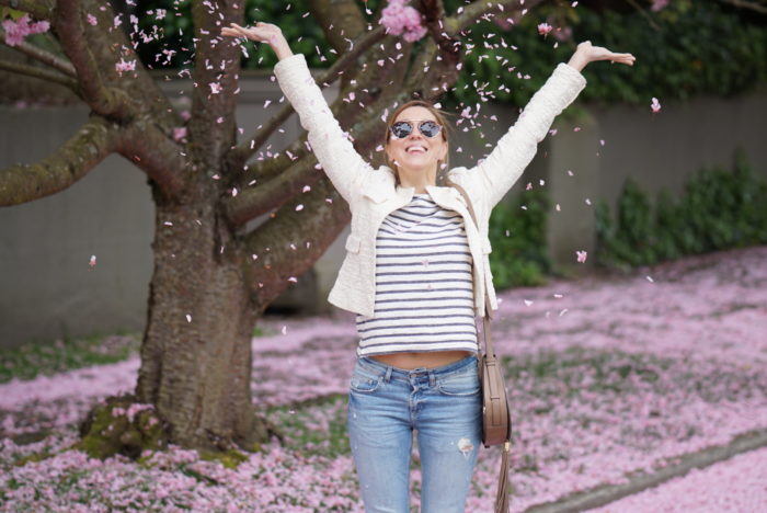 Christine Cameron wearing a vince camuto saddle bag next to cherry blossoms on queen anne hill in seattle 3