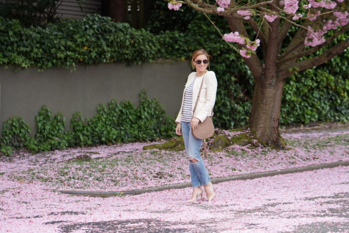 Christine Cameron wearing a vince camuto saddle bag next to cherry blossoms on queen anne hill in seattle 6