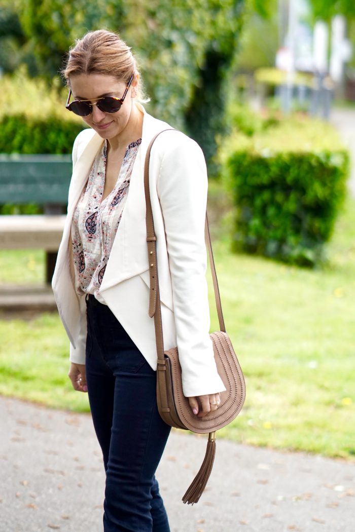 Christine Cameron wearing a white blazer with dark wide leg denim by Hudson and Vince Camuto purse 2